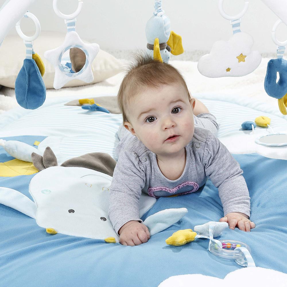 Ein Baby krabbelt auf der Fehn 3D Activity Krabbeldecke Little Castle mit Rassel und Spiegel